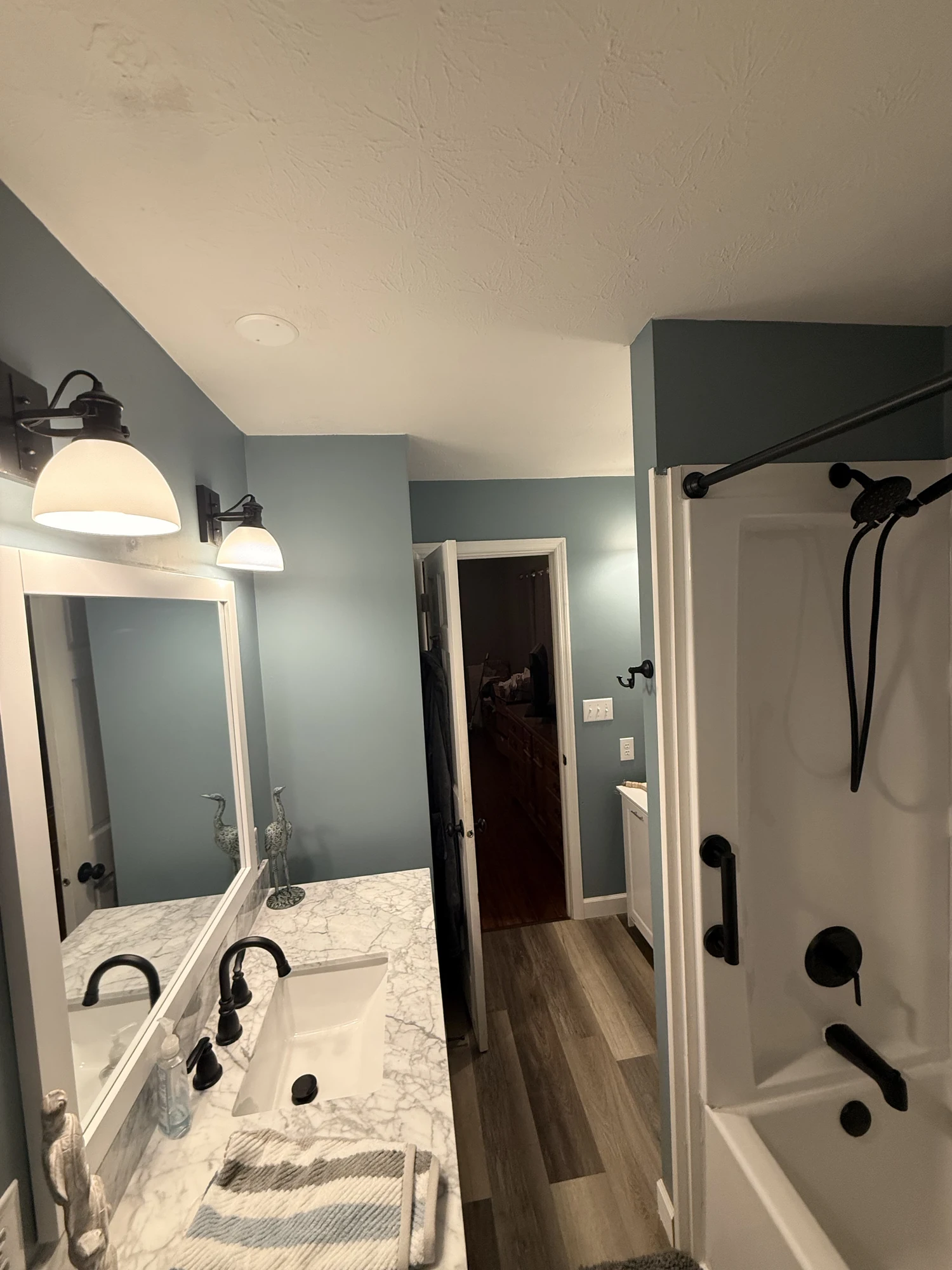 Finished blue bathroom showing the vanity, black shower fixtures and completed flooring; another angle of the same Shorehome Kentucky project.