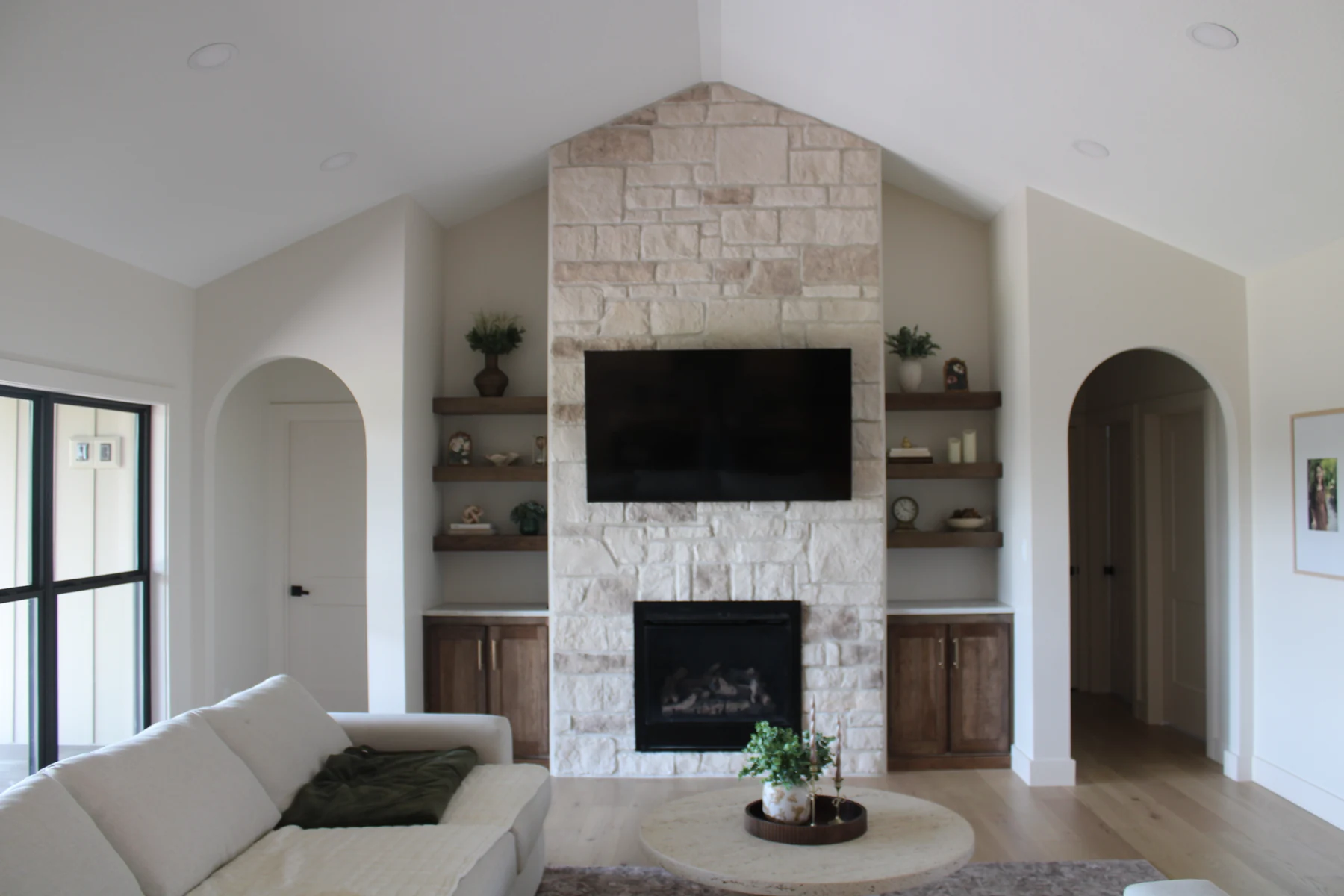 Bright living room with a stone fireplace and arched openings at a Shorehome Kentucky project